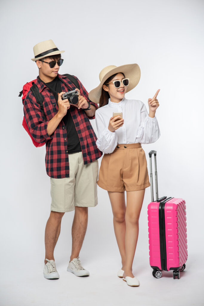 Men and women dressed to travel, wear glasses, and take pictures